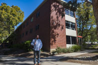 Chris Lambert, a musician and recording engineer, poses Thursday, April 15, 2021, in front of Muir Hall dormitory at California Polytechnic University in San Luis Obispo, Calif. Lambert started a podcast to document the 1996 disappearance of Kristin Smart, who was a college student at Cal Poly and lived in Muir Hall when she disappeared. On Tuesday, April 13, 2021, the San Luis Obispo County sheriff announced arrests in the 25-year-old case, crediting Lambert with helping bring in witnesses that propelled the case forward. (AP Photo/Nic Coury)