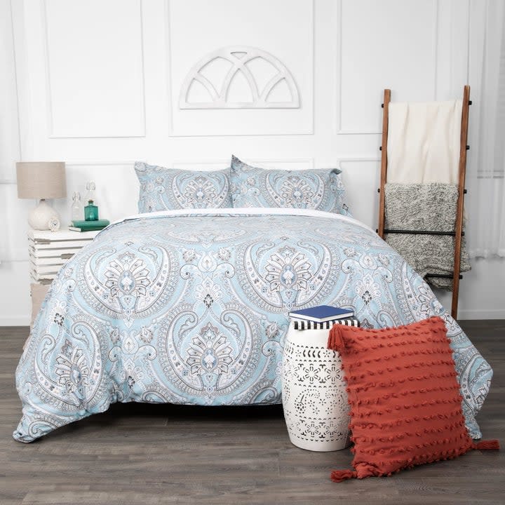 The damask-print comforter on a bed with two matching shams
