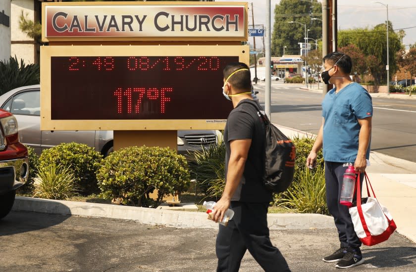 WOODLAND HILLS, CA - AUGUST 19: Anthony Aco and Troy Sacaguin, left to right, check out the thermometer at Calvary Church in Woodland Hills as it registers 117 degree's Fahrenheit Wednesday afternoon as the Southland's fiercest heat wave entered its second week threatening "excessive heat" and elevated fire danger. Los Angeles on Wednesday, Aug. 19, 2020 in Woodland Hills, CA. (Al Seib / Los Angeles Times