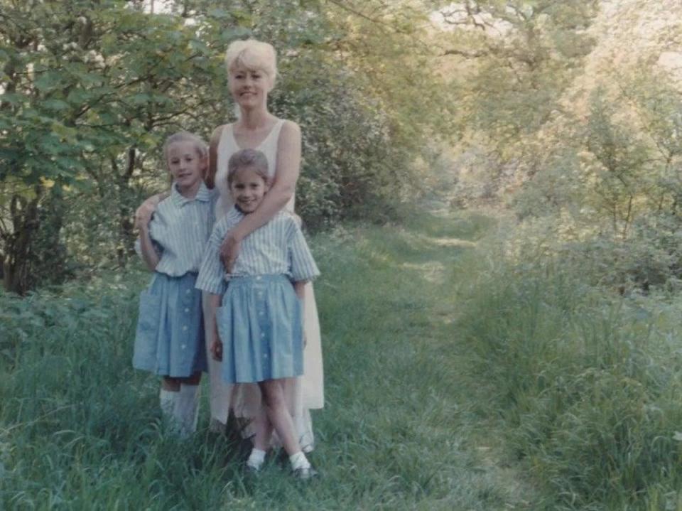 A young Caroline Flack pictured alongside her twin sister Jody and mother Christine (PA)