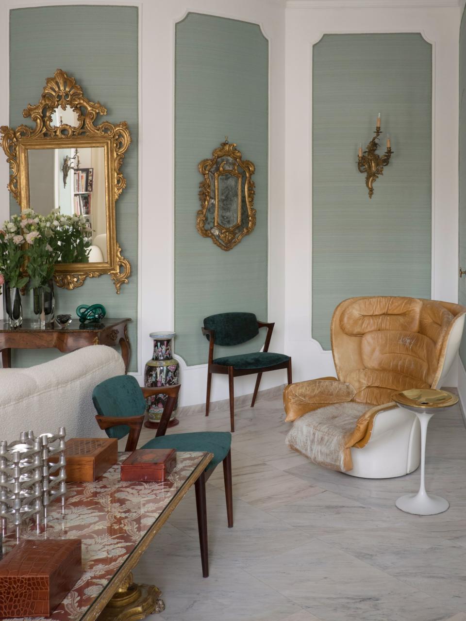 A vintage Joe Colombo lounge chair mingles with Kai Kristiansen armchairs and array of other treasures in the living room.