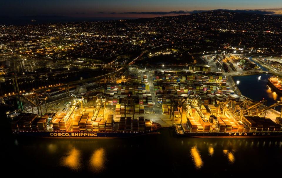 An aerial view of shipping containers sitting stacked at the Port of Los Angeles at night on April 15, 2022 in San Pedro, California.
