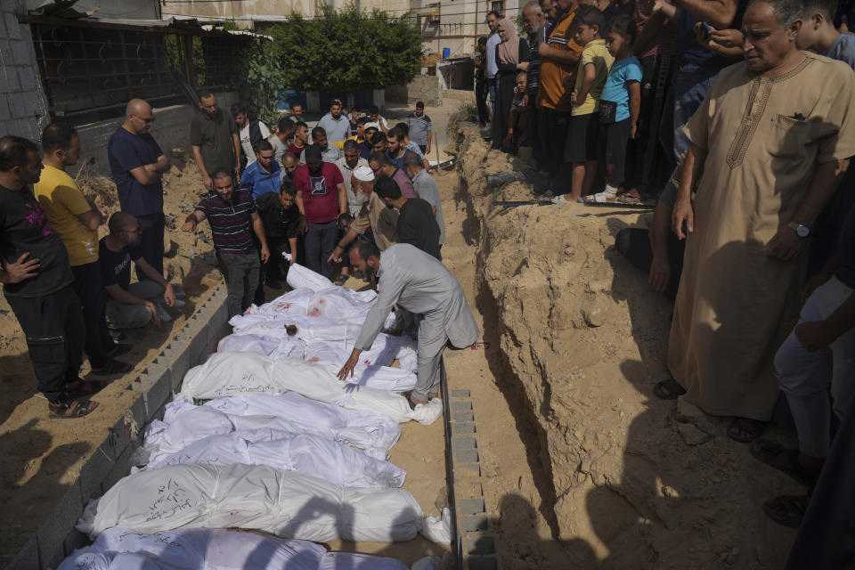 FILE- Palestinians bury the bodies of their relatives, killed in the Israeli bombardment of the Gaza Strip, Monday, Oct. 23, 2023, at a cemetery in Deir Al-Balah, Gaza, As the fifth Israel-Hamas war rages, growing more deadly and devastating, international and local monitoring groups in besieged Gaza have been unable to keep up. (AP Photo/Hatem Moussa, File)