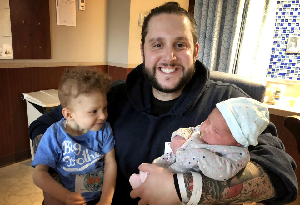 Image: Jonathan Coelho holds his son Braedyn and daughter Penelope. (Courtesy of Caitlin Pereira)