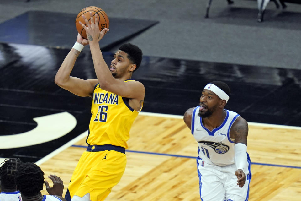 Indiana Pacers guard Jeremy Lamb (26) shoots in front of Orlando Magic guard Terrence Ross during the second half of an NBA basketball game, Friday, April 9, 2021, in Orlando, Fla. (AP Photo/John Raoux)