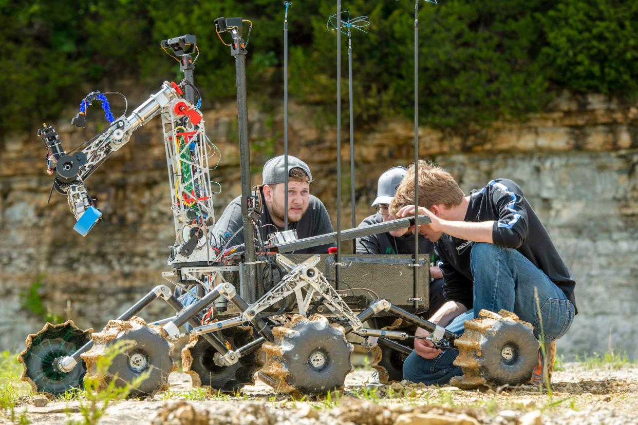 From left, Missouri S&T students Keyton Rovka, Brady Tappel and Sean Duda troubleshoot a battery issue on their Mars Rover, named Prometheus, on a May 27 test run at Fugitive Beach in Rolla.