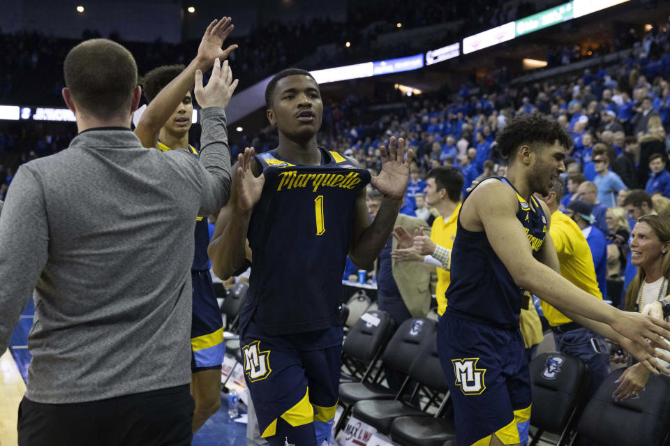 Marquette's Kam Jones, center, celebrates with teammates Oso Ighodaro, left, and Stevie Mitchell, right, following their 73-71 win against Creighton during an NCAA college basketball game on Tuesday, Feb. 21, 2023, in Omaha, Neb. (AP Photo/Rebecca S. Gratz)