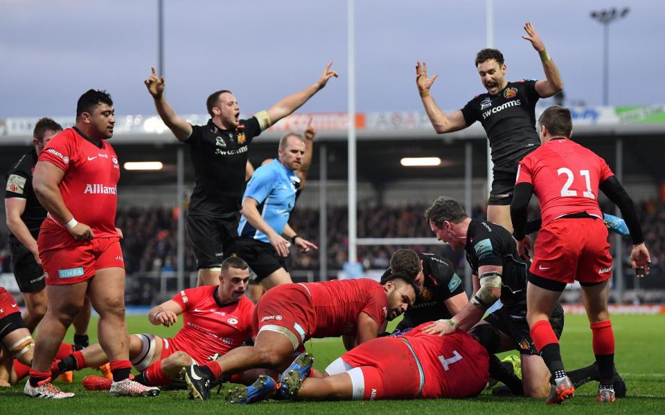 Exeter Chiefs players celebrate as Jacques Vermeulen dives over to score against Saracens - GETTY IMAGES