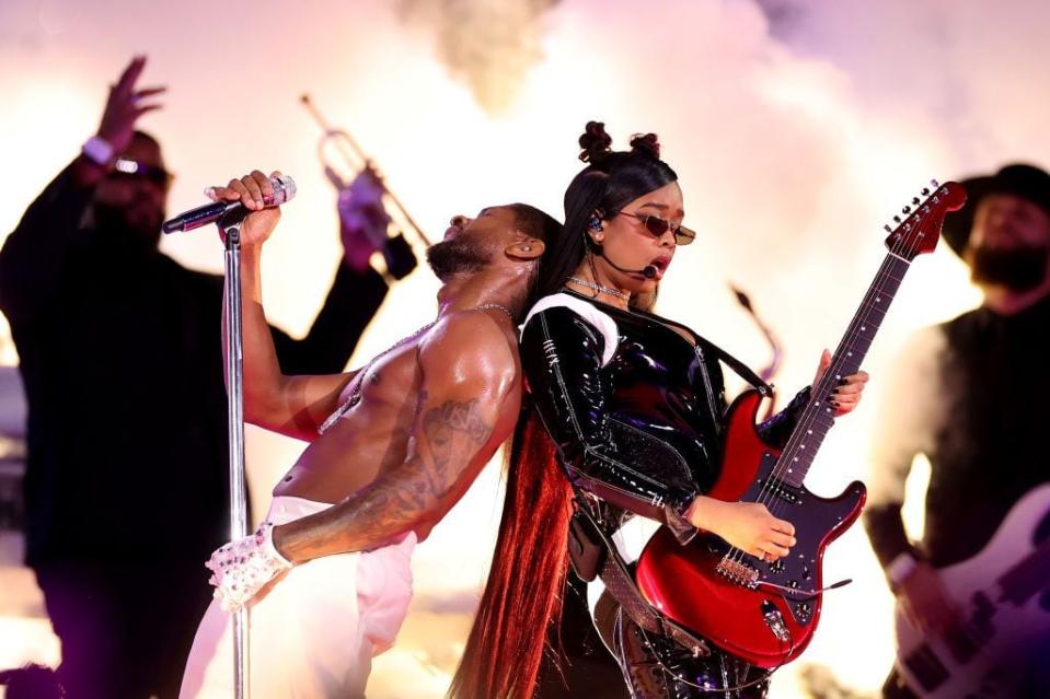 Usher and H.E.R. perform onstage during halftime.