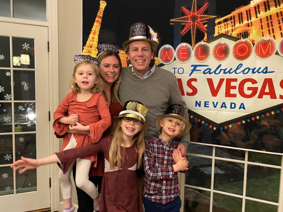 Abby Adair Reinhard, husband Josh and their three kids pose for a family photo during a celebration at home where they pretended to travel to Las Vegas.