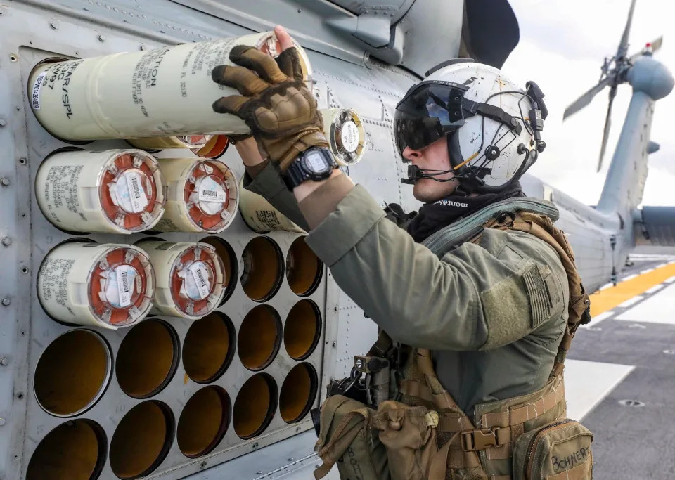 A US naval aircrewman checks sonobouys loaded onto a MH-60R Sea Hawk helicopter.
