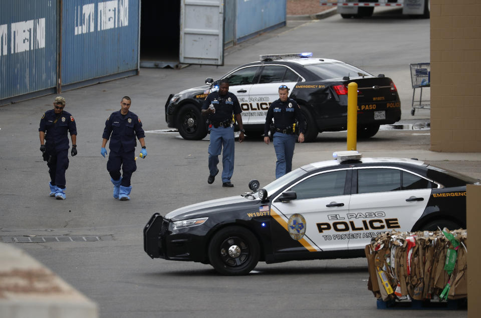 Police officers walk behind a Walmart at the scene of a mass shooting at a shopping complex Tuesday, Aug. 6, 2019, in El Paso, Texas. Patrick Crusius, 21, opened fire Saturday at the mall that largely caters to the local Mexican-American community. (AP Photo/John Locher)