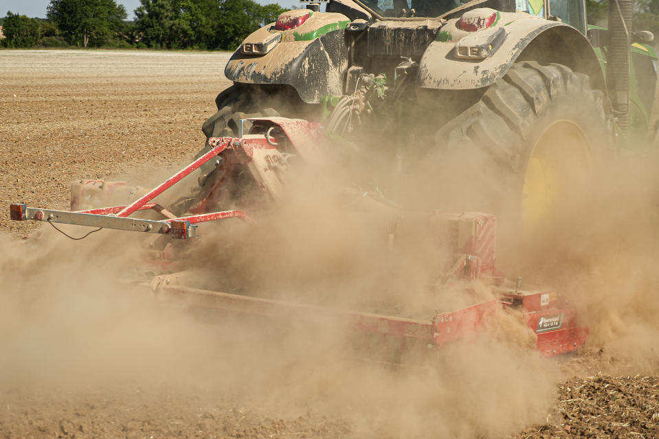 A tractor throws up a cloud of dust as it works in a sun-dried field in Til-Chatel, France, Tuesday Aug. 9, 2022. Burgundy, home to the source of the Seine River which runs through Paris, normally is a very green region. This year, grass turned yellow, depriving livestock from fresh food, and tractors send giant clouds of dust in the air as farmers work in their dry fields. (AP Photo/Nicholas Garriga)