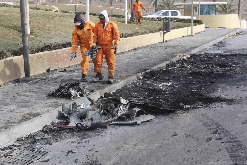 Cleaners work at scene of car bomb explosion outside Corinthia hotel in Libya's capital Tripoli