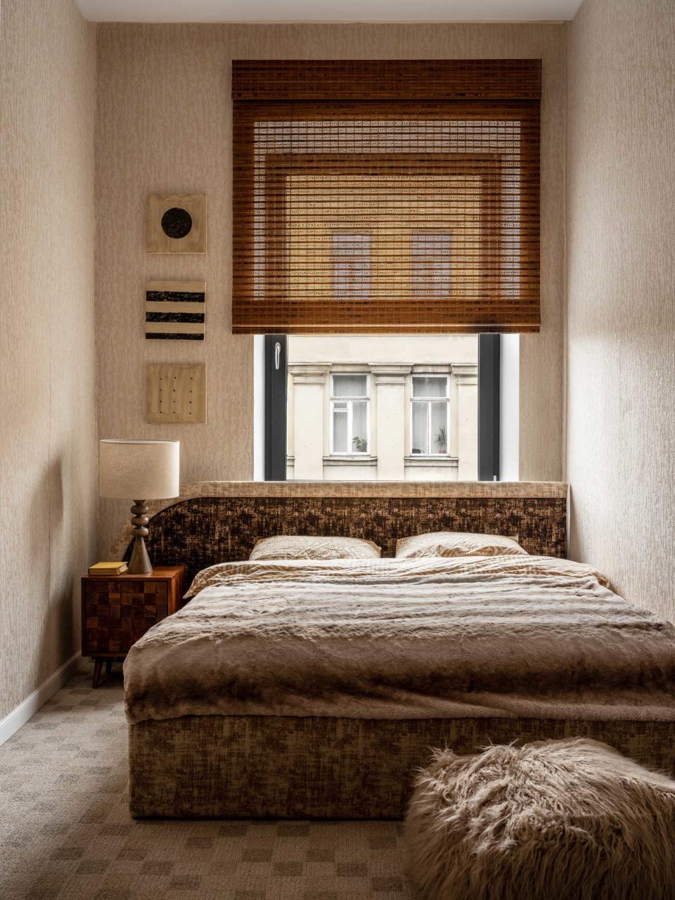 a small bedroom with a bed in front of the window