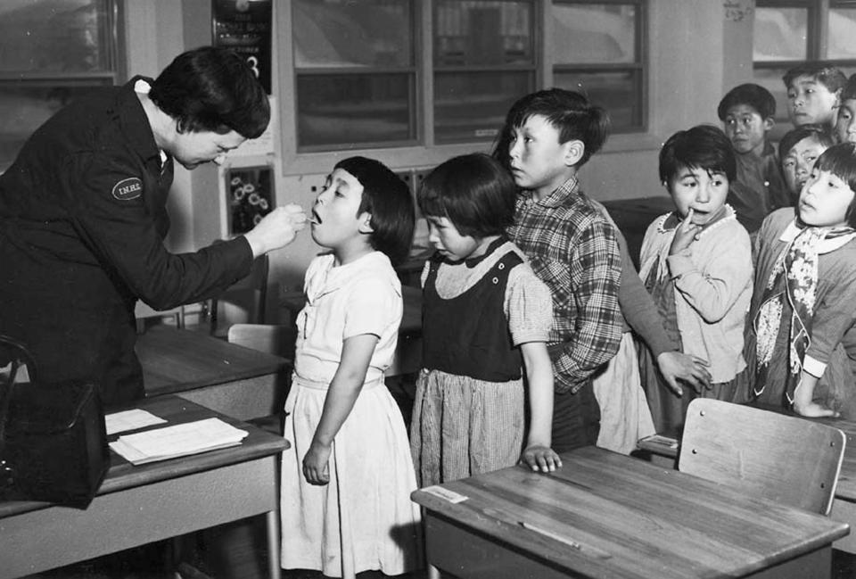 Nurse Desrochers checks a girl's throat while other children wait in line, at the Frobish Bay Federal Hostel in Iqaluit, Nunavut, in a 1959 archive photo. A Canadian policy of forcibly separating aboriginal children from their families and sending them to residential schools amounted to "cultural genocide," a six-year investigation into the now-defunct system found on June 2, 2015. The residential school system attempted to eradicate the aboriginal culture and to assimilate aboriginal children into mainstream Canada, said the long-awaited report by the Truth and Reconciliation Commission of Canada. REUTERS/H. Leclair/Canada. Health and Welfare Canada collection/Library and Archives Canada/e002504641/handout via Reuters