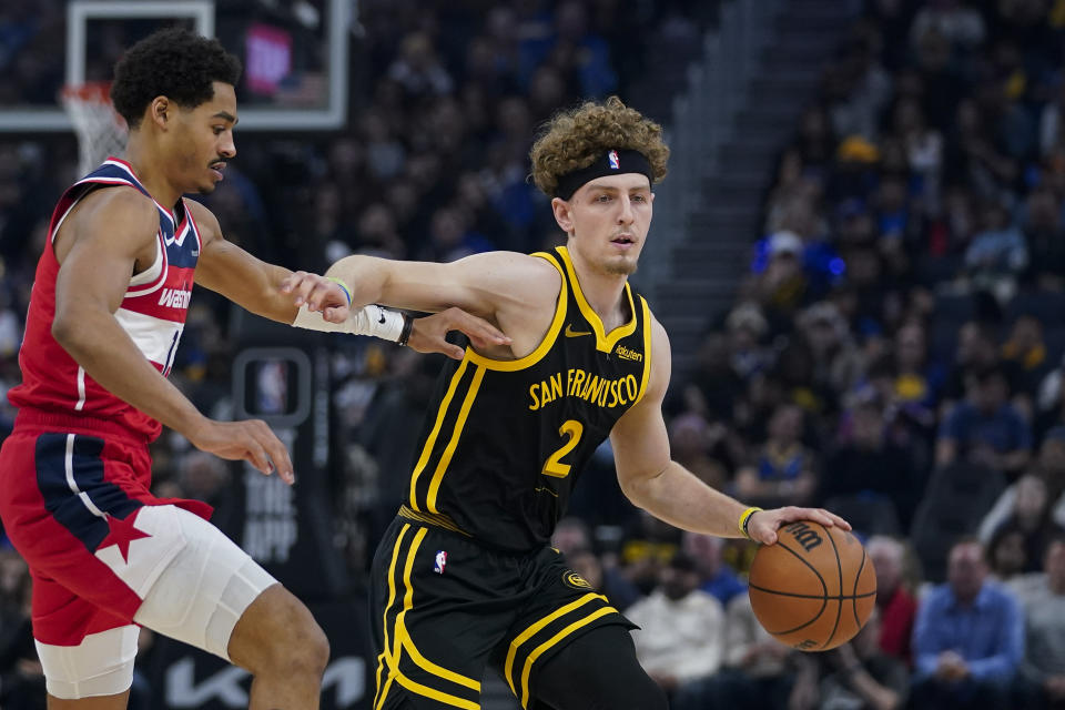 Golden State Warriors guard Brandin Podziemski, right, moves the ball while defended by Washington Wizards guard Jordan Poole, left, during the first half of an NBA basketball game Friday, Dec. 22, 2023, in San Francisco. (AP Photo/Godofredo A. Vásquez)