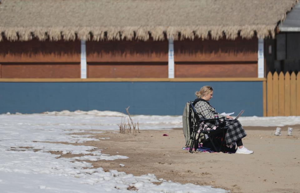 Lily Olson of Mukwonago, a sophomore at Marquette University studying speech pathology, takes advantage of the warm weather by studying at Bradford Beach in Milwaukee on Saturday, Feb. 27.