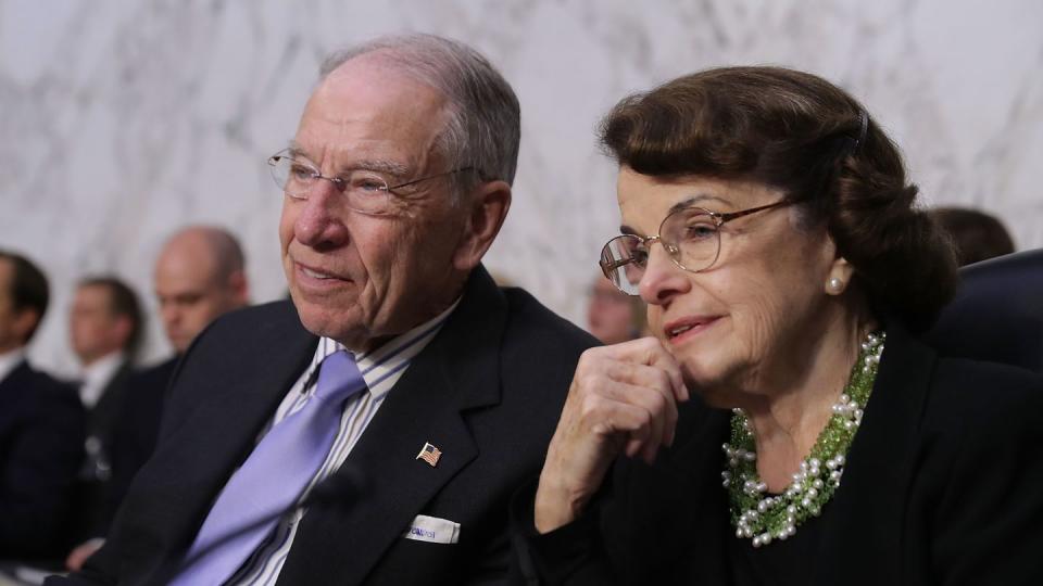 senator charles grassley and dianne feinstein, both wearing glasses, seated and listening to something off camera