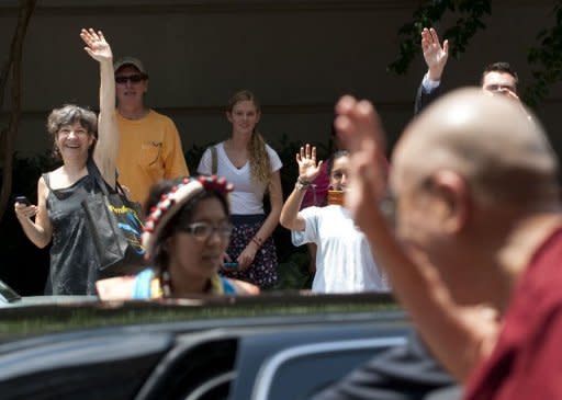 Wellwishers wave as the Tibetan spiritual leader the Dalai Lama arrives at his hotel in Washington, DC, July 5, 2011