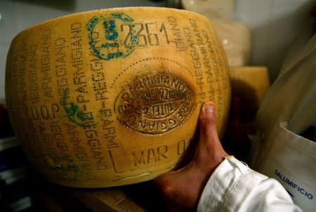 FILE PHOTO: An Italian grocer shows off his Parmesan cheese inside a shop in Rome