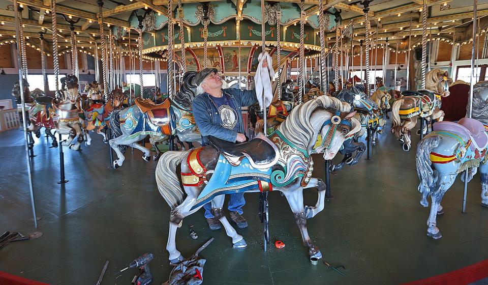 James Hardison polishes the chrome pole kids will hold onto while riding the newly refinished horse on the 1928 Paragon Carousel.