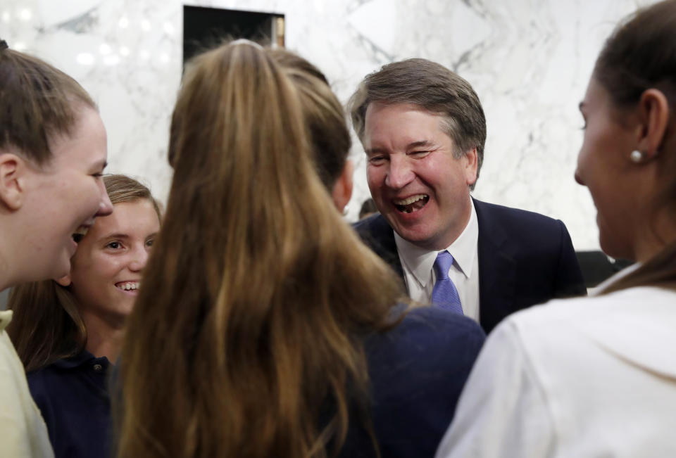 President Donald Trump's Supreme Court nominee, Brett Kavanaugh shares a laugh with members of his former basketball team during a break in testimony before the Senate Judiciary Committee on Capitol Hill in Washington, Thursday, Sept. 6, 2018, for the third day of his confirmation hearing to replace retired Justice Anthony Kennedy. (AP Photo/Alex Brandon)