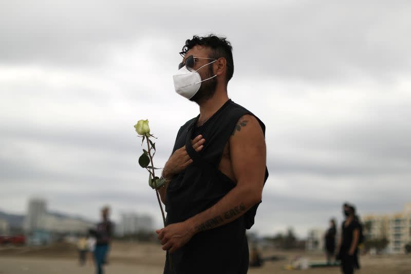 Daniel Martinez watches surfers at The Black Girls Surf paddle-out in memory of George Floyd, who died in Minneapolis police custody, in Santa Monica