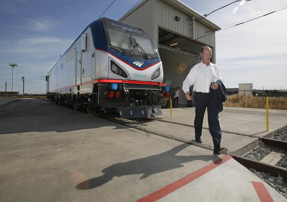 In this photo taken Saturday, May 11, 2013, Michael Cahill, president of Siemens Rail Systems, walks past one of the new Amtrak Cities Sprinter Locomotive that was built by Siemens in Sacramento, Calif. The new electric locomotive, one of three of 70 to be built, will run on the Northeast intercity rail lines and replace Amtrak locomotives that have been in service for 20 to 30 years.(AP Photo/Rich Pedroncelli)