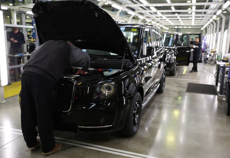A worker checks over a finished vehicle on the TX electric taxi production line inside the LEVC (London Electric Vehicle Company) factory in Coventry