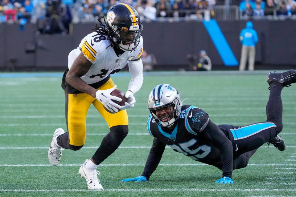 Dec 18, 2022; Charlotte, North Carolina, USA; Pittsburgh Steelers wide receiver Diontae Johnson (18) eludes Carolina Panthers safety Xavier Woods (25) during the second half at Bank of America Stadium. Mandatory Credit: Jim Dedmon-USA TODAY Sports