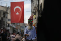 A man walks at a market in Istanbul, Wednesday, Aug. 15, 2018. The Turkish lira has nosedived in value in the past week over concerns about Turkey's President Recep Tayyip Erdogan's economic policies and after the United States slapped sanctions on Turkey angered by the continued detention of an American pastor. (AP Photo/Lefteris Pitarakis)