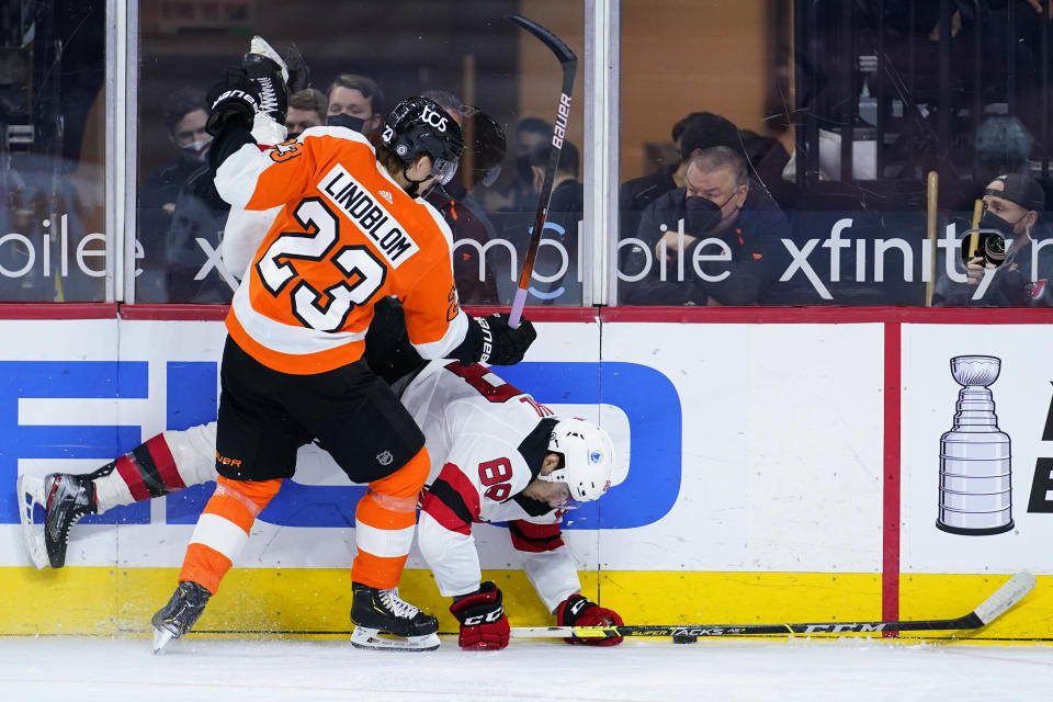 Philadelphia Flyers' Oskar Lindblom (23) and New Jersey Devils' Kevin Bahl (88) collide during the second period of an NHL hockey game, Monday, May 10, 2021, in Philadelphia. (AP Photo/Matt Slocum)