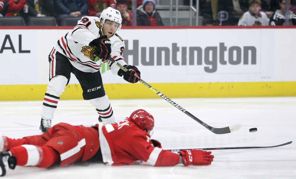 Chicago Blackhawks center Drake Caggiula (91) passes the puck against Detroit Red Wings defenseman Filip Hronek (17) during the first period of an NHL hockey game Friday, March 6, 2020, in Detroit. (AP Photo/Duane Burleson)