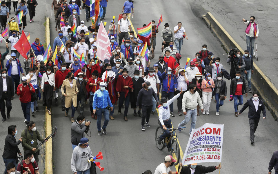 El candidato presidencial Yaku Pérez saluda desde una bicicleta mientras él y sus partidarios llegan a Quito, Ecuador, después de una marcha de protesta de una semana desde el sur hasta la capital, el martes 23 de febrero de 2021. Pérez está pidiendo al Consejo Nacional Electoral una recuento de las boletas electorales presidenciales del 7 de febrero, diciendo que él es el subcampeón legítimo, no Guillermo Lasso, quien las autoridades electorales anunciaron que quedó en segundo lugar y se enfrentará al principal candidato Andrés Arauz en una segunda vuelta en abril. (AP Foto/Dolores Ochoa)