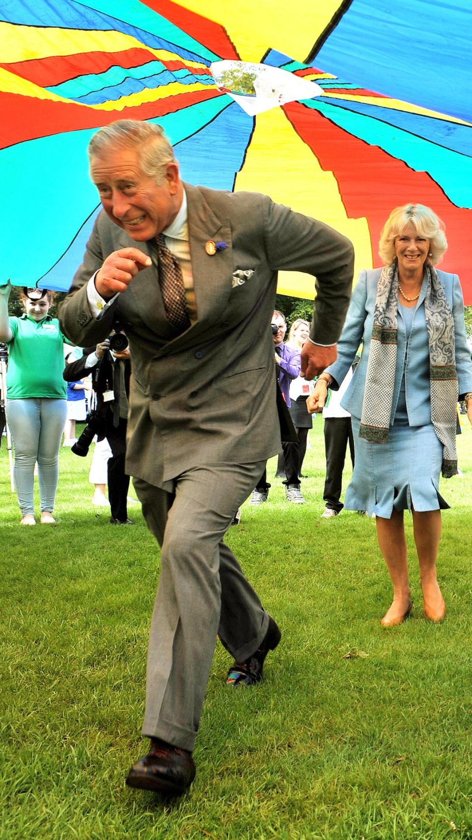 King Charles and Camilla under a parachute.