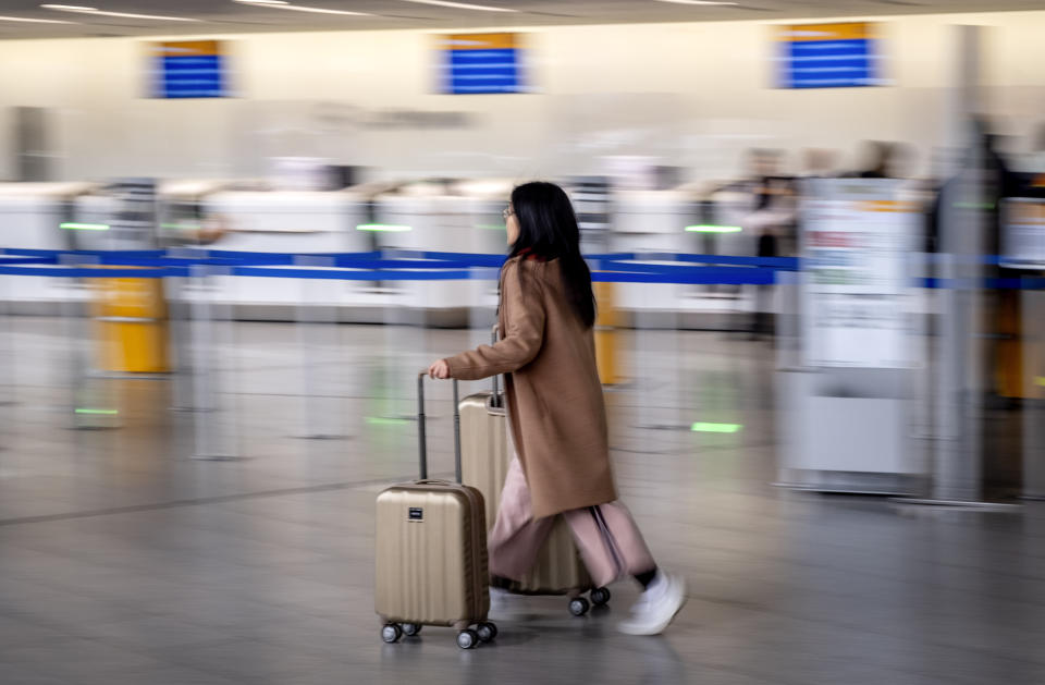 A passenger rushes through a terminal at the airport in Frankfurt, Germany, Tuesday, Feb. 20, 2024. The trade union Verdi has once again called on Lufthansa ground staff to go on a warning strike. (AP Photo/Michael Probst)