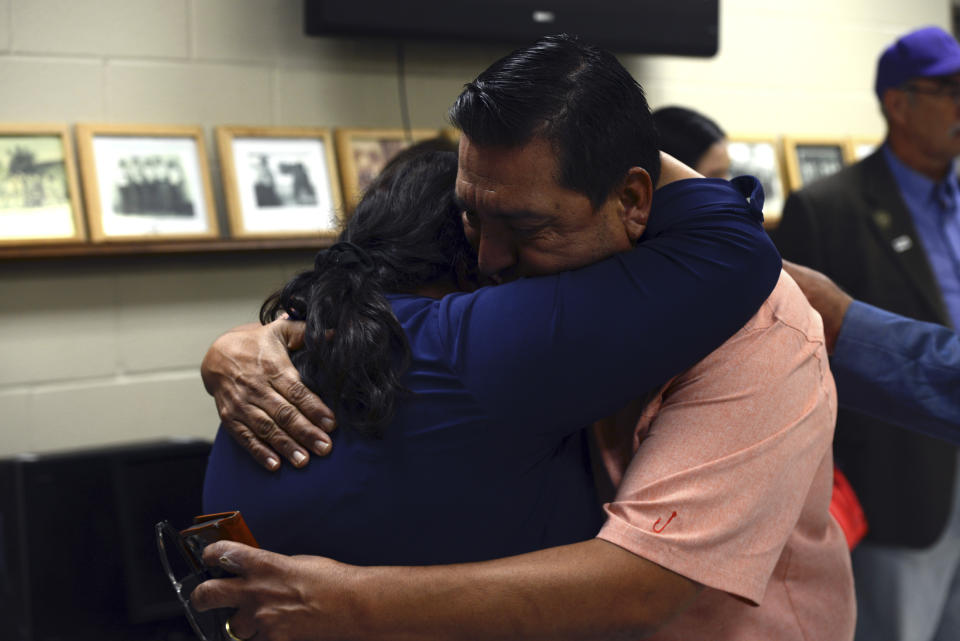 The widow of slain San Benito Police Officer Lt. Milton Resendez, who was killed in the line of duty, is embraced during a San Benito Police Department press conference Wednesday, Oct 18, 2023, in San Benito, Texas. (Miguel Roberts/The Brownsville Herald via AP)