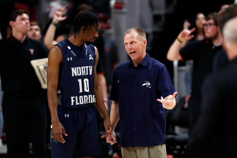 North Florida coach Matthew Driscoll talks to Jarius Hicklen (10) during the second half of an NCAA college basketball game against North Florida, Tuesday, Nov. 9, 2021, in Lubbock, Texas.