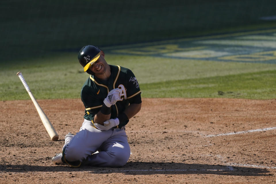 Oakland Athletics' Tommy La Stella reacts after being hit by a pitch against the Houston Astros during the eighth inning of Game 3 of a baseball American League Division Series in Los Angeles, Wednesday, Oct. 7, 2020. La Stella left the game after the play. (AP Photo/Ashley Landis)