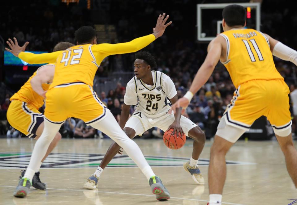 Akron guard Ali Ali (24) controls the ball between a host of Kent State defenders during the Mid-American Conference Tournament championship game March 16 in Cleveland.