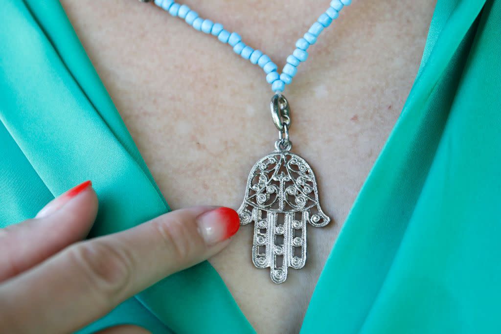 woman wearing a muslim hamsa amulet, also known of the hand of fatima or the hand of mary