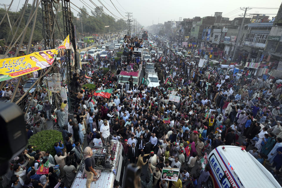 Supporters of Pakistan's main opposition 'Tehreek-e-Insaf party' listen the speech of their leader Imran Khan at a rally in Lahore, Pakistan, Saturday, Oct. 29 2022. Khan along with thousands of his supporters in a large convoy of buses and cars Friday began his much-awaited march on the capital Islamabad from the eastern city of Lahore to demand the holding of snap elections, a sign of deepening political turmoil. (AP Photo/K.M. Chaudary)