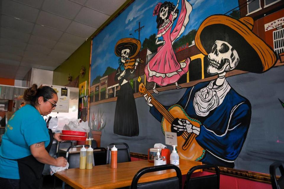 Guadalupe Banuelos clears a table during the lunch hour at Ricos Tacos Lupe, 802 Southwest Blvd. Her grandmother, Esther Gonzales Rogers, came to Kansas City in the 1980s and now owns some 20 West Side properties. “Everything that’s here, we want to stay here,” Banuelos said of Hispanic businesses and neighbors. “This is our home.”