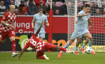 Mainz's Leandro Barreiro and Cologne's Denis Huseinbasic, right, battle for the ball during the Bundesliga soccer match between FSV Mainz 05 and 1. FC Koln at Mewa Arena, Mainz, Germany, Sunday April 28, 2024. (Torsten Silz/dpa via AP)