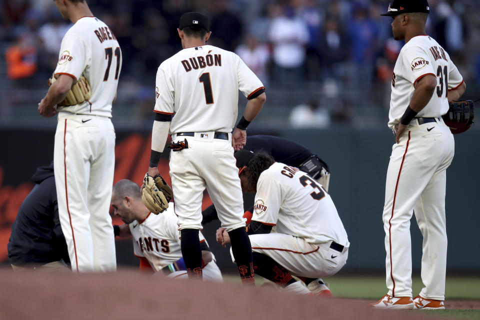San Francisco Giants third baseman Evan Longoria (10) sits up after colliding with shortstop Brandon Crawford during the ninth inning of the team's baseball game against the Chicago Cubs on Saturday, June 5, 2021, in San Francisco. (AP Photo/Scot Tucker)