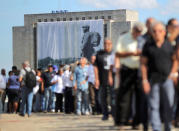 A large portrait of Cuba's late President Fidel Castro hangs from a building while people wait in line to pay tribute to Castro in Havana, Cuba, November 28, 2016. REUTERS/Carlos Barria