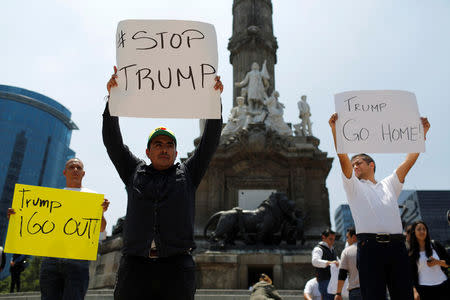 Demonstrators hold placards during a protest against the visit of U.S. Republican presidential candidate Donald Trump, at the Angel of Independence monument in Mexico City, Mexico, August 31, 2016. REUTERS/Tomas Bravo