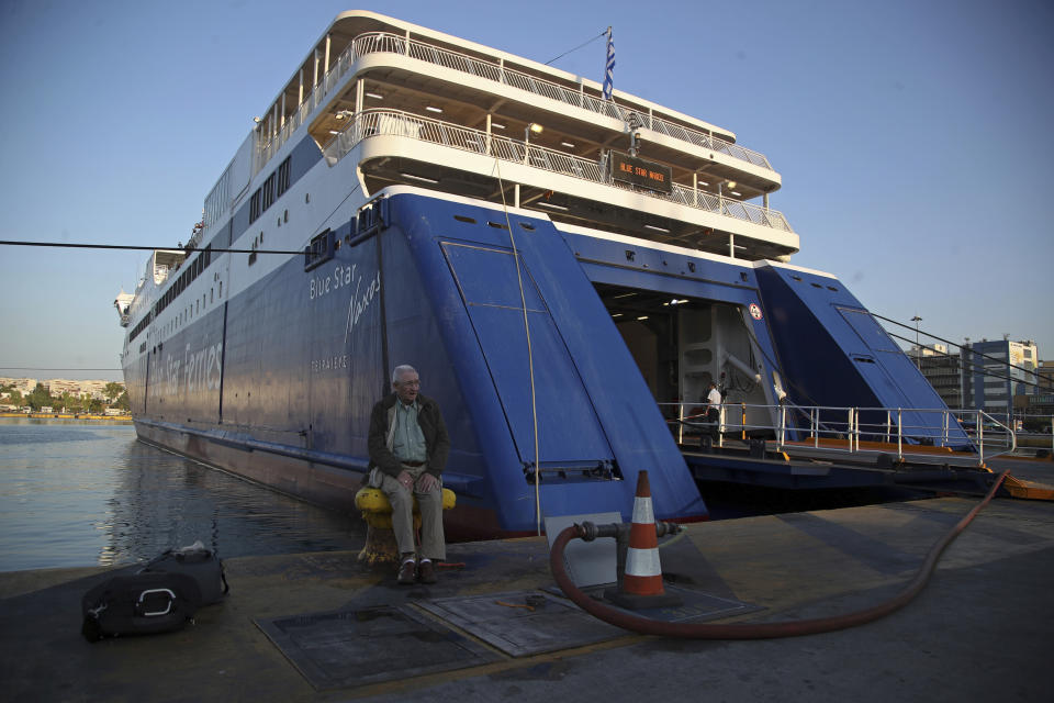 An elderly man sits on a bollard of a docked ferry during seamen's unions strike at the port of Piraeus, near Athens, Monday, Sept. 3, 2018. Ferries are due to be halted by a 24-hour strike Monday, as unions seek the return of benefits and pay scales scrapped or frozen during eight years of international bailouts that ended in late August. (AP Photo/Thanassis Stavrakis)