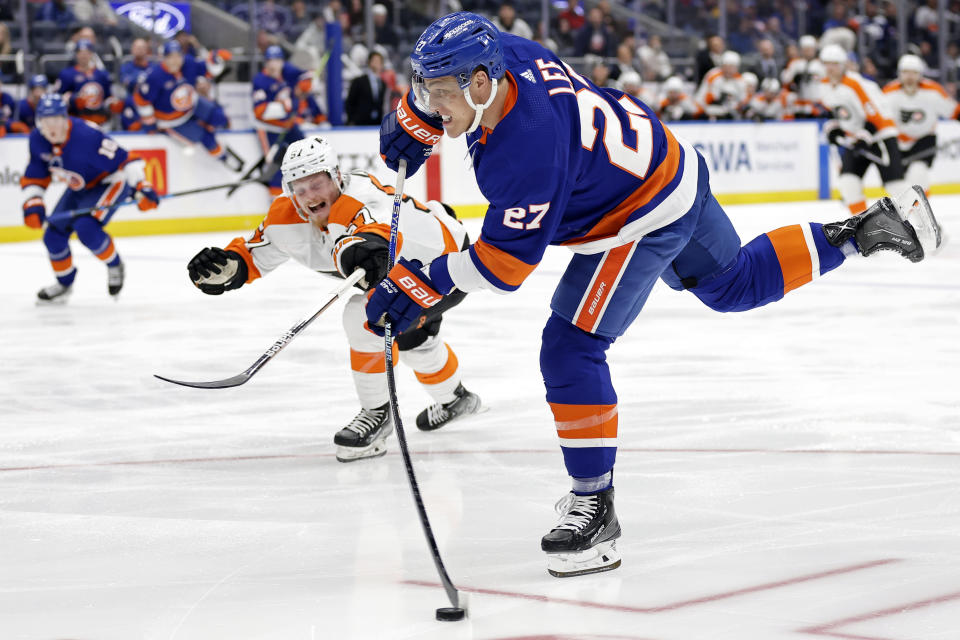 New York Islanders left wing Anders Lee (27) shoots in front of Philadelphia Flyers right wing Wade Allison in the second period of an NHL hockey game Saturday, April 8, 2023, in Elmont, N.Y. (AP Photo/Adam Hunger)